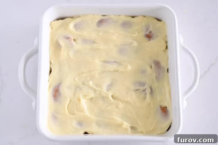 White square 8X8 baking dish with vanilla pudding layered over nilla wafers.