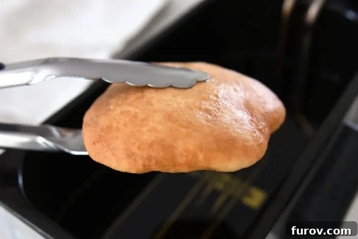 Piece of fry bread dough in electric oil fryer.