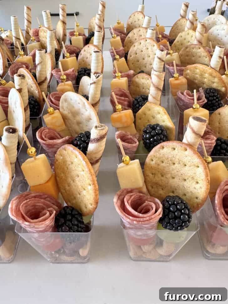 Mini charcuterie cups on white counter.