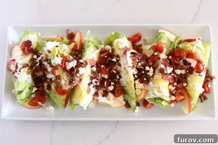Loaded Wedge Salad with Bacon, Blue Cheese and Ranch Dressing 11 White platter with iceberg wedges, tomatoes, sliced apples, bacon, blue cheese crumbles, and blue cheese dressing.