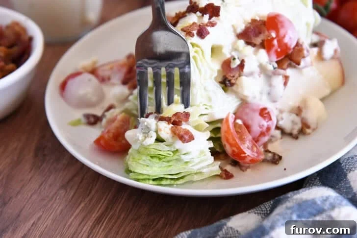 Loaded Wedge Salad with Bacon, Blue Cheese and Ranch Dressing 12 White plate with one iceberg wedge, blue cheese crumbles, blue cheese dressing, tomatoes, bacon, and sliced apples.