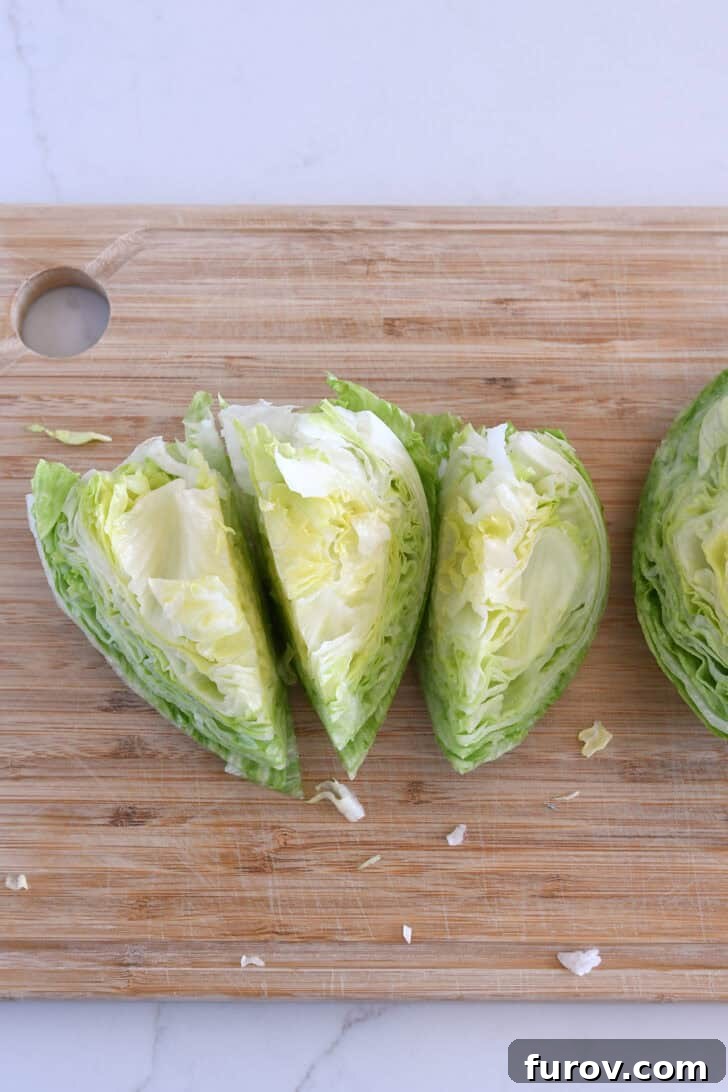 Loaded Wedge Salad with Bacon, Blue Cheese and Ranch Dressing 5 Wood cutting board with iceberg wedges.
