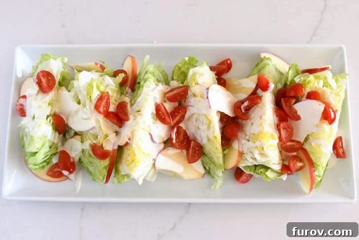 Loaded Wedge Salad with Bacon, Blue Cheese and Ranch Dressing 9 White platter with iceberg wedges, tomatoes, sliced apples, and blue cheese dressing.