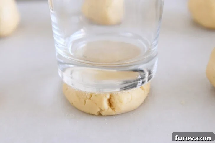 Copycat Swig Coconut Lime Sugar Cookies 3 Pressing sugar cookie dough ball into thick disc with sugared bottom drinking glass.