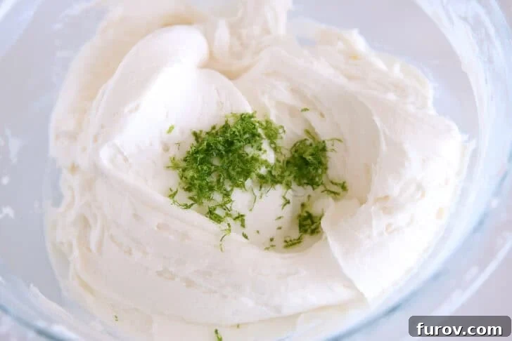 Copycat Swig Coconut Lime Sugar Cookies 6 Glass bowl with mixed coconut lime frosting and fresh lime zest.