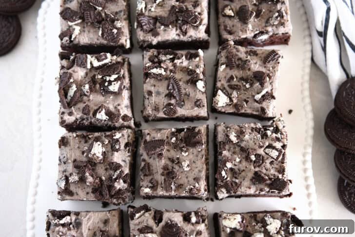 Nine squares of cookies and cream oreo brownies on white tray.