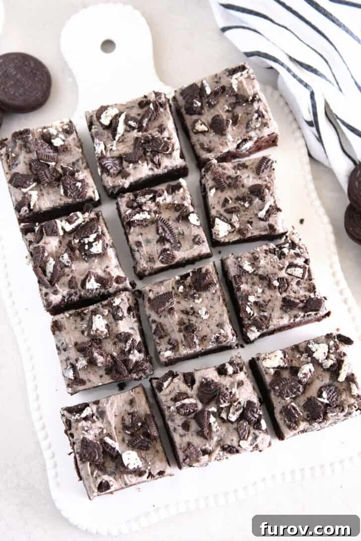 Nine squares of cookies and cream oreo brownies on white tray.