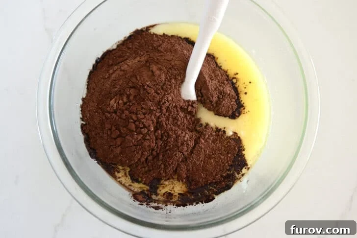 Glass bowl with melted butter, sugar and cocoa powder.