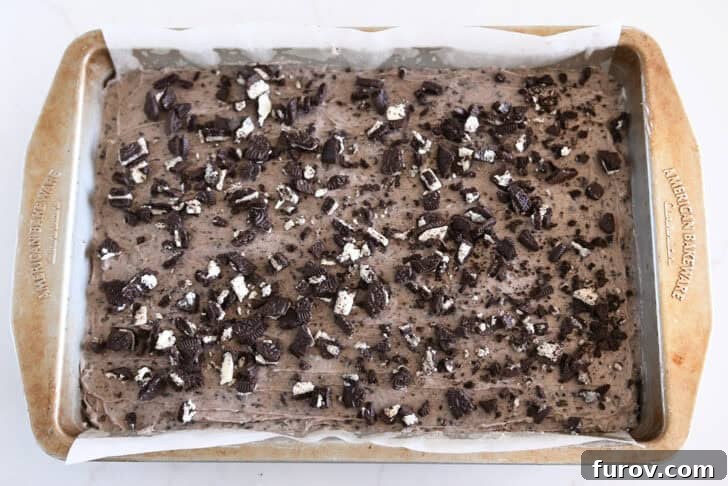 Chopped Oreo sprinkled on top of Oreo-frosted brownies.