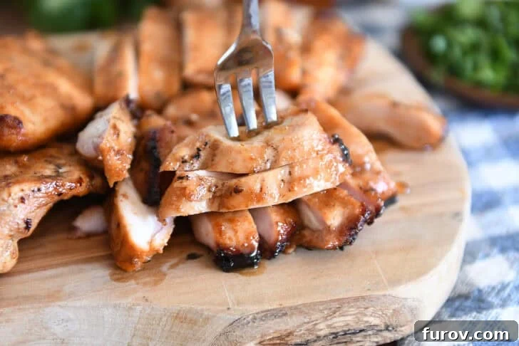 Wood tray with sliced pieces of grilled chicken.