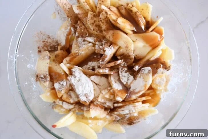 Glass bowl with sliced apples, caramel and flour.