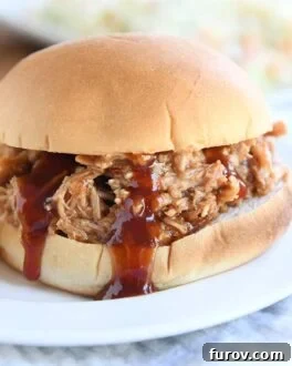 BBQ pork sandwich on bun on white plate
