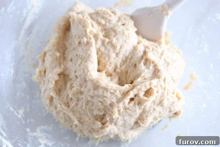 Fluffy Cinnamon Roll Bites Recipe: Soft, Bite-Sized Treats 4 Wet roll dough mixed in glass bowl.